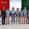 Năm thuyền viên Indonesia cùng đại diện các cơ quan đơn vị tại buổi lễ bàn giao. (Ảnh: TTXVN/phát)