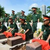 Nghi thức an táng hài cốt các liệt sỹ tại nghĩa trang liệt sỹ huyện Hướng Hóa. (Ảnh: Hồ Cầu/TTXVN)