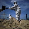 Nhóm tình nguyện đào huyệt mộ giả trên bãi biển Copacabana,để tưởng nhớ những người đã tử vong vì dịch bệnh viêm đường hô hấp cấp COVID-19 tại Rio de Janeiro, Brazil, ngày 11/6. (Ảnh: AFP/TTXVN)