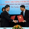 Phó chủ tịch UBND thành phố Đà Nẵng Hồ Kỳ Minh (bên phải) chúc mừng Trưởng văn phòng JICA tại Việt Nam Shimizu Akira. (Ảnh: Quốc Dũng/TTXVN)