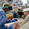 Nhân viên y tế điều trị cho bệnh nhân COVID-19 tại bệnh viện ở Italy. (Ảnh: AFP/TTXVN)
