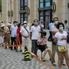 Người dân xếp hàng chờ lấy mẫu xét nghiệm COVID-19 tại thành phố Đại Liên, tỉnh Liêu Ninh, Trung Quốc ngày 28/7. (Ảnh: AFP/TTXVN)