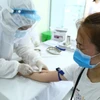 Nhân viên y tế lấy mẫu xét nghiệm nhanh cho người về từ Đà Nẵng, tại phường Bách Khoa và phường Cầu Dền, quận Hai Bà Trưng sáng 01/8. (Ảnh: Minh Quyết/TTXVN)