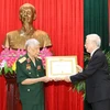 Tổng Bí thư, Chủ tịch nước Nguyễn Phú Trọng, Bí thư Quân ủy Trung ương trao Huy hiệu 70 năm tuổi Đảng tặng đồng chí Lê Khả Phiêu. (Ảnh: Trí Dũng/TTXVN)