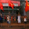 Người dân ở trên tuyến đường Nguyễn Thị Minh Khai vui mừng sau khi hoàn thành cách ly 14 ngày trong khu vực phong tỏa. (Ảnh: Trần Lê Lâm/TTXVN)