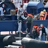 Lực lượng bảo vệ biên giới Anh đưa người di cư vượt biển từ Pháp qua Eo biển Manche, tới cảng Dover ở bờ biển đông nam nước Anh ngày 9/8 vừa qua. (Ảnh: AFP/TTXVN)
