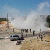 Người Syria tập trung tại địa điểm do một thiết bị nổ ở tuyến tuần tra chung Thổ Nhĩ Kỳ-Nga trên đường cao tốc chiến lược M4, gần thị trấn Ariha của Syria ở tỉnh Idlib. (Nguồn: AFP via Getty Images)