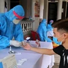 Các cán bộ y tế tiến hành xét nghiệm nhanh COVID-19 cho người dân ở thành phố Đông Hà trở về từ vùng có dịch. (Ảnh: Hồ Cầu/TXVN)
