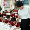 Giáo viên trường Tiểu học Chu Văn An, thành phố Nam Định, tỉnh Nam Định hướng dẫn học sinh làm bài tập. (Ảnh: Nguyễn Lành/TTXVN)