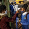 Đo thân nhiệt phòng lây nhiễm COVID-19 tại trường học ở Ekurhuleni của Nam Phi. (Ảnh: AFP/TTXVN)