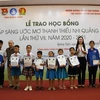 Đại diện Nhóm những người bạn Quảng Ngãi tại TP Hồ Chí Minh và lãnh đạo tỉnh Quảng Ngãi trao học bổng cho các em học sinh. (Ảnh: Đinh Hương/TTXVN)