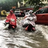 Ôtô, xe máy lưu thông trong biển nước do mưa lớn tại ngã tư Phan Bội Châu-Lý Thường Kiệt. (Ảnh: Lâm Khánh/TTXVN)