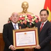 Thứ trưởng Bộ Ngoại giao Lê Hoài Trung trao Huân chương Hữu nghị cho Cố vấn đặc biệt Nội các Thủ tướng Nhật Bản Iijima Isao. (Ảnh: Văn Điệp/TTXVN)