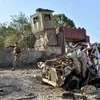 Lực lượng an ninh Afghanistan điều tra tại hiện trường một vụ đánh bom xe. (Ảnh: AFP/TTXVN)