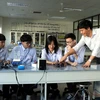 Thầy giáo trường THPT chuyên Bắc Ninh hướng dẫn những học sinh vừa đạt giải cuộc thi Olympic trẻ thế giới làm thí nghiệm Vật lý. (Ảnh: Đinh Văn Nhiều/TTXVN)