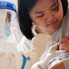 Nhân viên y tế lấy mẫu xét nghiệm COVID-19 cho một em bé ở tỉnh Hà Bắc, Trung Quốc, ngày 13/1. (Ảnh: THX/TTXVN)