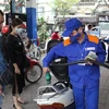 Nhân viên Petrolimex bơm xăng cho khách hàng. (Ảnh: Đức Duy/Vietnam+)