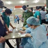 Nhân viên Trung tâm Y tế quận Bình Thạnh, TP.HCM chuẩn bị lấy mẫu xét nghiệm tại Bến xe Miền Đông. (Ảnh: TTXVN phát)