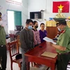 Cơ quan An ninh Điều Tra thuộc Công an tỉnh Ninh Thuận tống đạt quyết định khởi tố các bị can phạm tội mua bán, tàng trữ trái phép vật liệu nổ. (Ảnh: Công Thử/TTXVN)