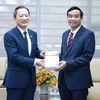 Phó chủ tịch UBND thành phố Đà Nẵng Lê Trung Chinh nhận quà từ Tổng lãnh sự Hàn Quốc tại Đà Nẵng Ahn Minh Sik. (Ảnh: Quốc Dũng/TTXVN)