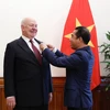 Thứ trưởng Bộ Ngoại giao Tô Anh Dũng trao Huân chương Hữu nghị của Chủ tịch nước cho Đại sứ Liên bang Nga tại Việt Nam Konstantin Vnukov. (Ảnh: Dương Giang/TTXVN)