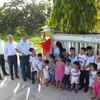 Đại diện Đại sứ quán Canada tại Việt Nam cùng các sơ và em nhỏ ở Mái ấm Nhân Ái cắt băng khánh thành con đường. (Ảnh: Phan Sáu/TTXVN)