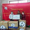 Ông Trần Đức Hiển, Phó Chủ nhiệm Ủy ban về Người Việt Nam ở nước ngoài TP.HCM (ngoài cùng, bên trái) trao tượng trưng kinh phí cho đại diện trường Tiểu học Hữu nghị tỉnh Champasak của Lào. (Ảnh: TTXVN phát)
