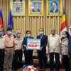 Chủ tịch Liên hiệp các tổ chức hữu nghị Việt Nam Nguyễn Phương Nga trao cho Đại sứ Campuchia tại Việt Nam Chay Navuth khoản hỗ trợ 500 triệu đồng. (Nguồn: qdnd)