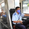 Lái xe buýt thực hiện nghiêm việc đeo khẩu trang y tế khi đang làm việc. (Ảnh: Thành Đạt/TTXVN)