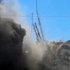 Tòa tháp Jala, nơi đặt văn phòng một số hãng truyền thông quốc tế, bị đổ sập do trúng không kích của Israel tại Dải Gaza, ngày 15/5. (Ảnh: AFP/TTXVN)
