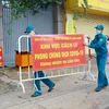 Lực lượng chức năng thực hiện dỡ bỏ phong tỏa cho 20 hộ dân tại khu phố 2, phường Xuân Thanh. (Ảnh: Lê Xuân/TTXVN)