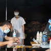 Lực lượng y tế tại chốt kiểm dịch chân cầu Yên Dũng nối tỉnh Bắc Ninh và Bắc Giang hỗ trợ người dân khai báo y tế. (Ảnh: Đinh Văn Nhiều/TTXVN)