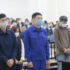 Bị cáo Nguyễn Nhật Cảm và các đồng phạm nghe Tòa tuyên án tại phiên tòa xét xử sơ thẩm vụ án Vi phạm quy định về đấu thầu gây hậu quả nghiêm trọng xảy ra tại CDC Hà Nội ngày 12/12/2020. (Ảnh: Doãn Tấn/TTXVN)