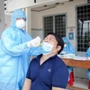Lấy mẫu xét nghiệm COVID-19 cho cán bộ, giáo viên làm công tác thi tốt nghiệp THPT tại Trung tâm Y tế thành phố Rạch Giá, tỉnh Kiên Giang. (Ảnh: Hồng Đạt/TTXVN)