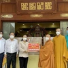 Hòa thượng Thích Thiện Nhơn trao bảng tượng trưng số máy thở đa năng cho bà Nguyễn Thị Lệ. (Ảnh: TTXVN phát)
