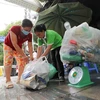 Người dân tới đổi rác tái chế lấy quà tại điểm đổi rác phường Cửa Đông, quận Hoàn Kiếm (Hà Nội). (Ảnh: Thanh Tùng/TTXVN)