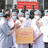 Chủ tịch nước Nguyễn Xuân Phúc tặng quà các nhân viên y tế làm việc cơ sở thu dung, điều trị bệnh nhân COVD-19 của Bệnh viện Đa khoa Hà Đông. (Ảnh: Thống Nhất/TTXVN)