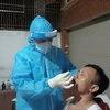 Ngành y tế Hà Tĩnh khẩn trương lấy mẫu xét nghiệm người dân tại khu vực phong tỏa trong đêm. (Ảnh: Hoàng Ngà/TTXVN)
