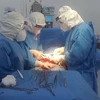 Êkíp y bác sỹ bệnh viện Quân dân y Đồng Tháp thực hiện phẫu thuật cho thai phụ mắc COVID-19 đang mang thai tuần thứ 39. (Ảnh: TTXVN phát)