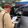 Lực lượng cảnh sát giao thông kiểm tra giấy tờ lưu thông của các lái xe. (Ảnh: Nguyễn Văn Cảnh/TTXVN)