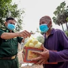 Đồn Biên phòng cửa khẩu Phước Tân trao thực phẩm thiết yếu cho người dân vùng biên có hoàn cảnh khó khăn. (Ảnh: Thanh Tân/TTXVN)