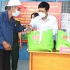 Bí thư Huyện ủy Xuân Lộc Viên Hồng Tiến (áo trắng ) trao quà hỗ trợ cho người dân khó khăn trong đại dịch. (Ảnh: TTXVN phát)