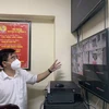 Chủ tịch UBND quận Thanh Xuân Võ Đăng Dũng theo dõi, điều hành việc di dời công dân qua hệ thống camera. (Ảnh: Văn Cảnh/TTXVN)