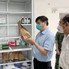 Bộ trưởng Bộ Y tế Nguyễn Thanh Long kiểm tra túi thuốc hỗ trợ điều trị cho F0 tại nhà. (Ảnh: TTXVN phát)