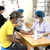Lực lượng y tế khám sàng lọc trước khi tiêm cho người dân tiêm vaccine phòng COVID-19. (Ảnh: Nguyễn Cúc/TTXVN)