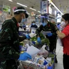 Nhiều chiến sỹ nhờ trợ giúp thông tin, hàng hóa từ các nhân viên siêu thị để "đi chợ giúp dân" đúng và đầy đủ theo nhu cầu." (Ảnh: Thanh Vũ/TTXVN)