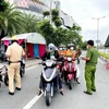 Lực lượng Công an tại chốt kiểm trên đường Phạm Văn Đồng, phường Hiệp Bình Chánh, Thủ Đức, kiểm tra giấy tờ của người lưu thông. (Ảnh: Thành Chung/TTXVN)