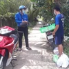 Lực lượng "Shipper áo xanh xứ Dừa" giao hàng đã mua giúp người dân Bến Tre. (Ảnh: Huỳnh Phúc Hậu/TTXVN)