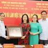 Bộ trưởng Bộ Giáo dục và Đào tạo Nguyễn Kim Sơn tặng quà lưu niệm cho nhà trường. (Ảnh: Hoàng Nguyên/TTXVN)