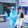 Lực lượng y tế lấy mẫu xét nghiệm sàng lọc SARS-CoV-2 cho người dân phường Nguyễn Du sáng 30/9. (Ảnh: Hoàng Hiếu/TTXVN)